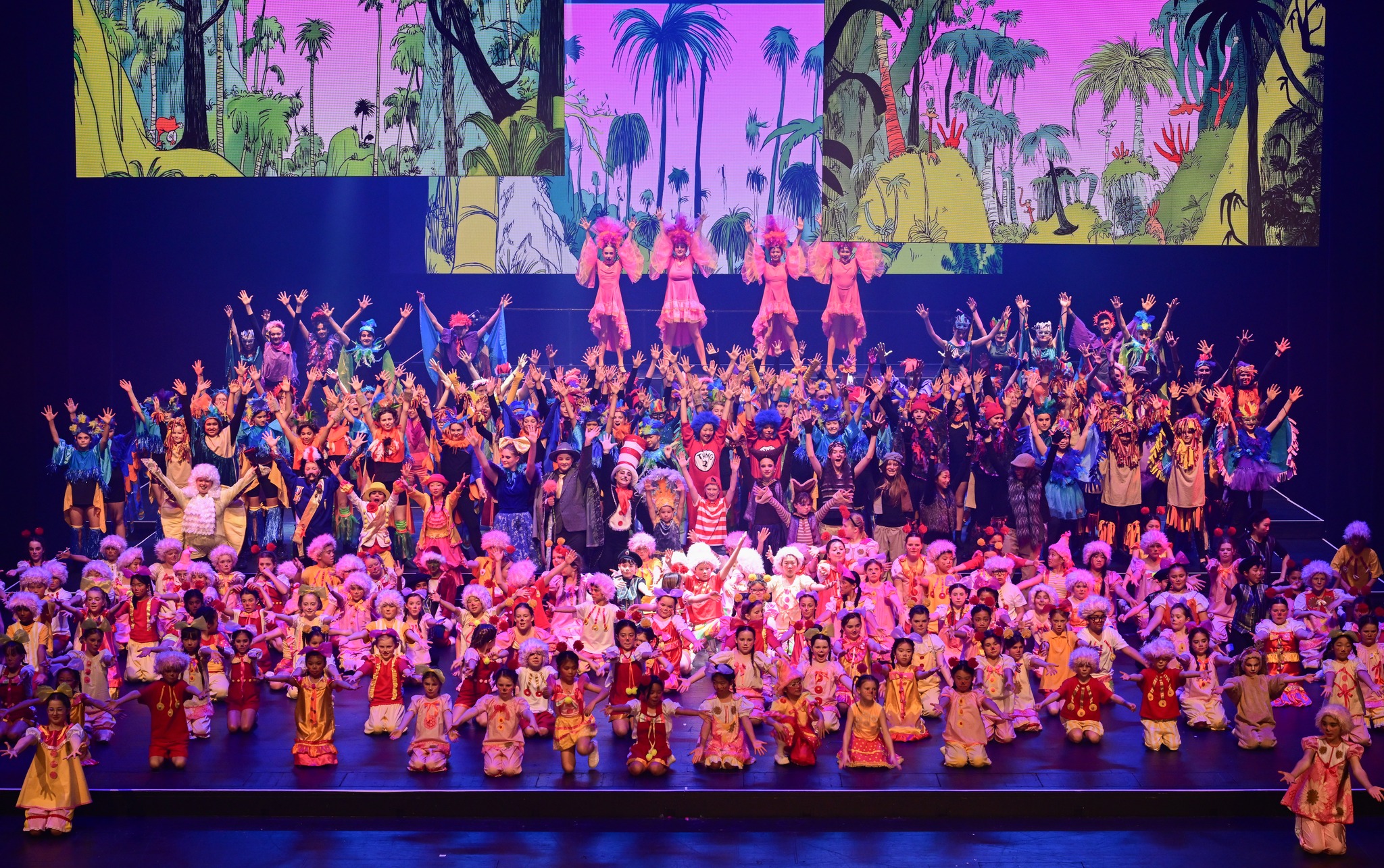 National Youth Theatre New Zealand — large ensemble cast on stage in colourful costumes
