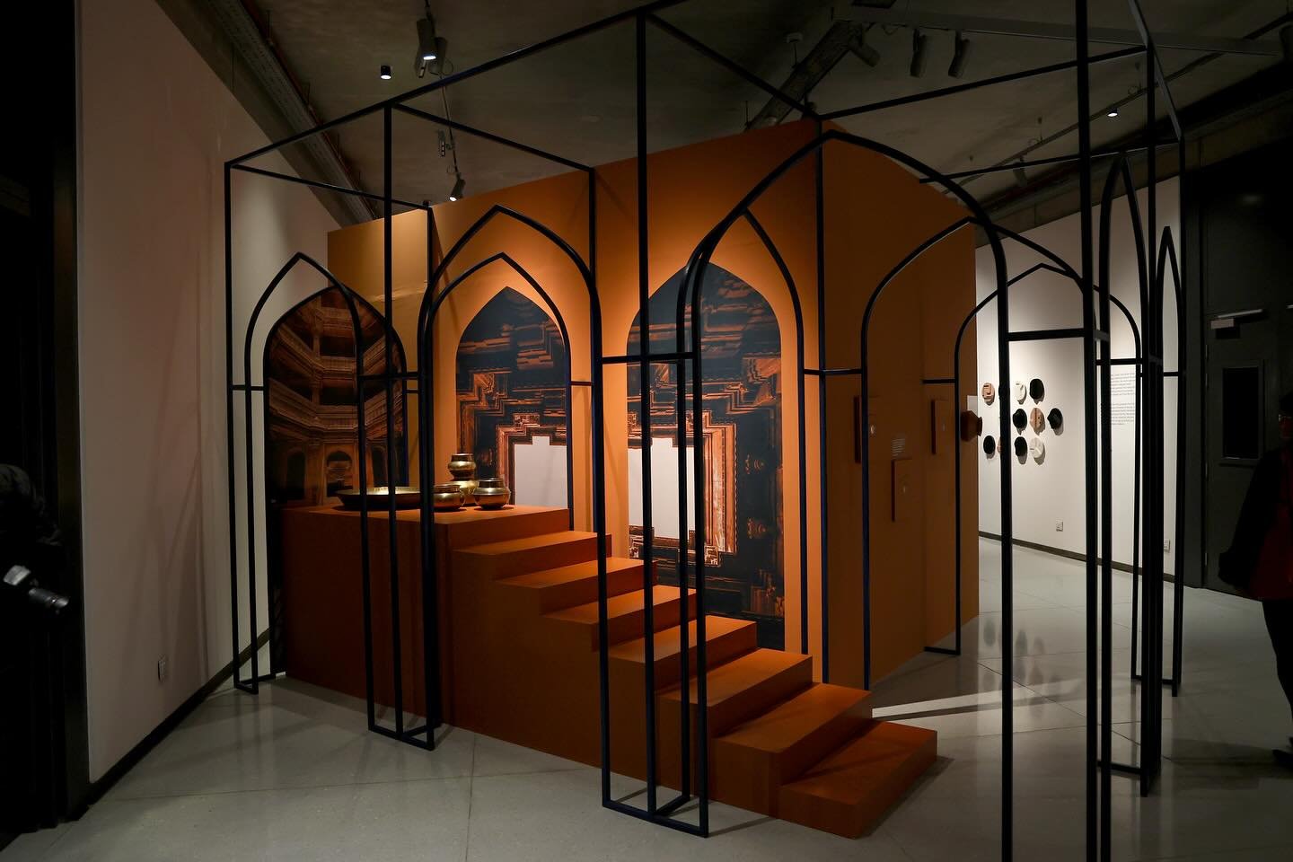 Public Arts Trust of India — gallery installation with arched steel frames and an orange stepped plinth