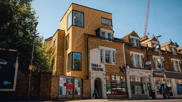 Tara Theatre building facade in London with distinctive modern architecture integrated into historic brick structures, street-level storefront with theatre signage